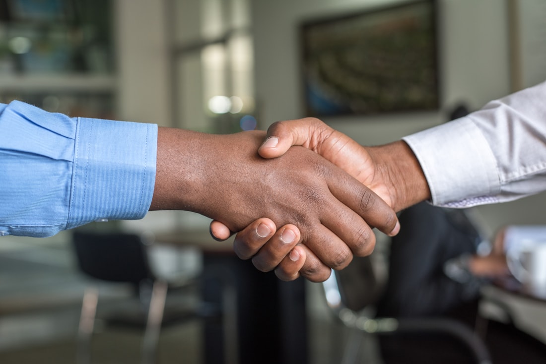 Two professionals shaking hands representing AZK liability insurance coverage