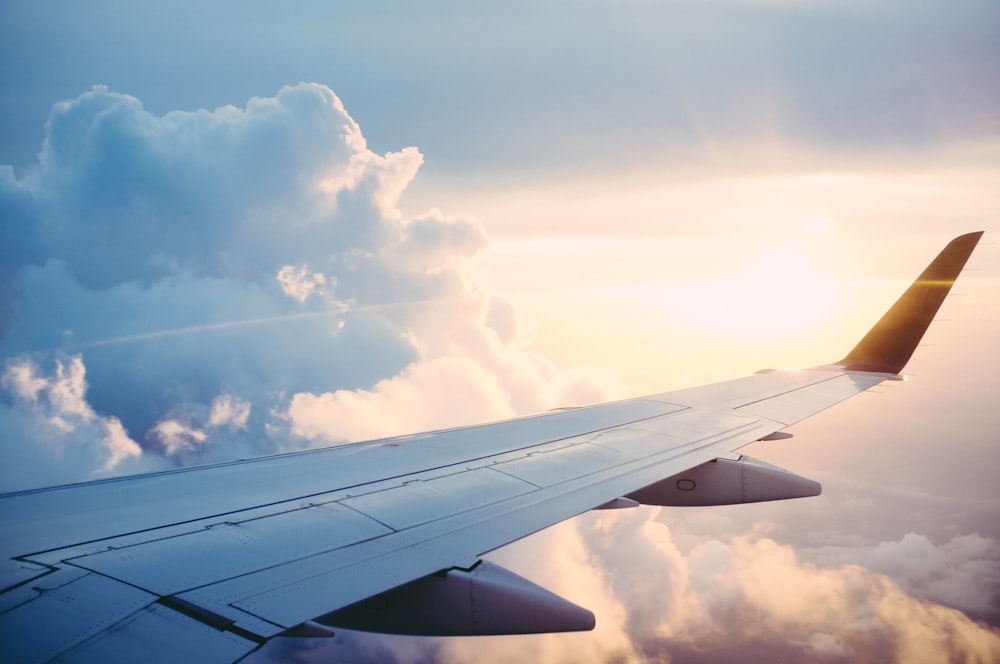 Airplane wing above the clouds representing AZK travel insurance coverage